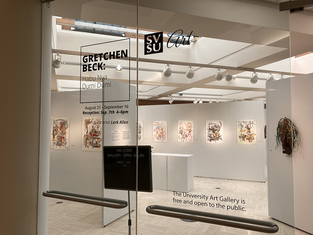 entry way of exhibition with title wall and bio in background